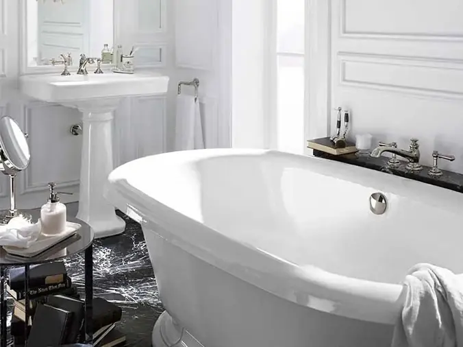 Feww standing bathtub with pedistal sink in the background